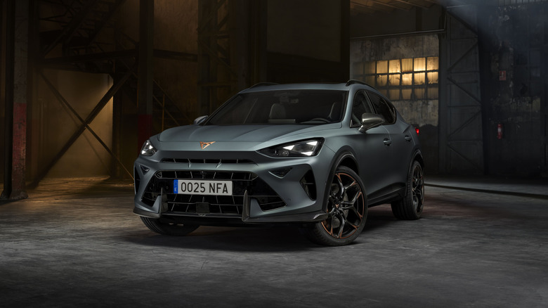 Cupra Formentor in matte gray in a dimly lit abandoned warehouse, front 3/4 view