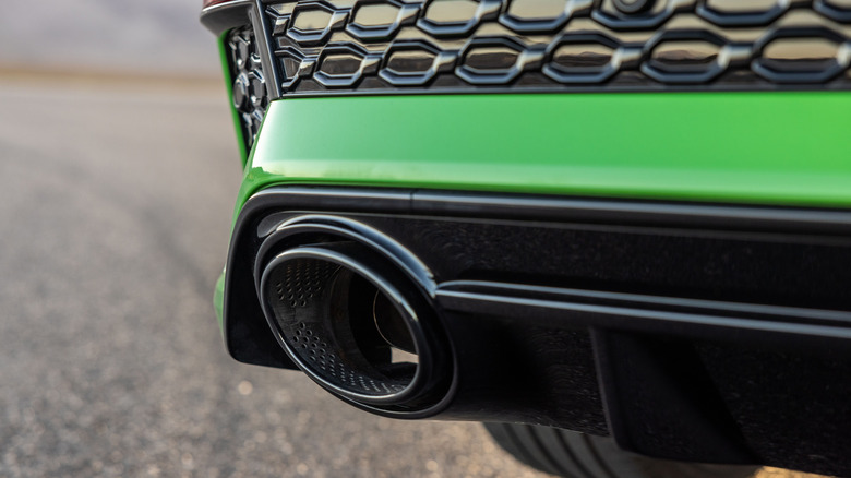 A close-up of the left exhaust pipe on the Audi RS3, green exterior