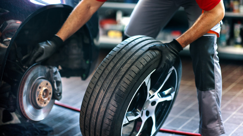 Mechanic installing new tire on vehicle
