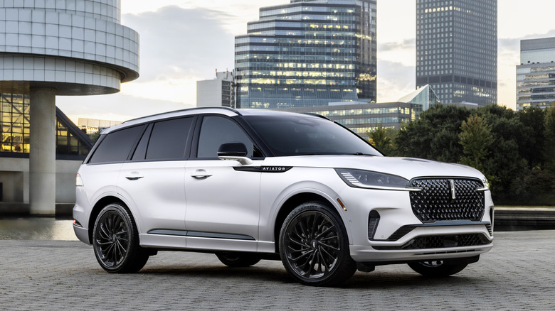 2025 Lincoln Aviator on modern home driveway with cityscape in background, front-right view