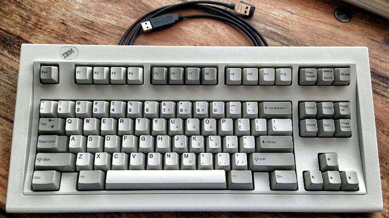 A gray IBM Model M keyboard on a table.
