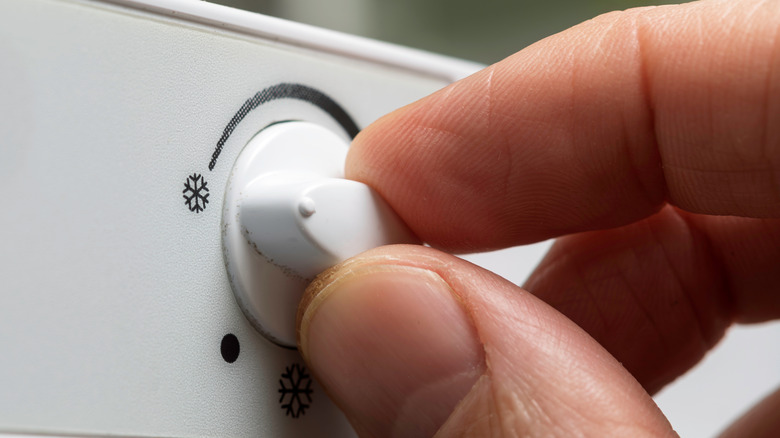 A person adjusting the snowflake dial on their refrigerator