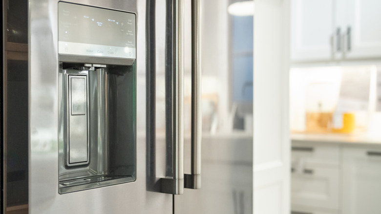 A close-up of a gray home refrigerator and its ice maker in the kitchen