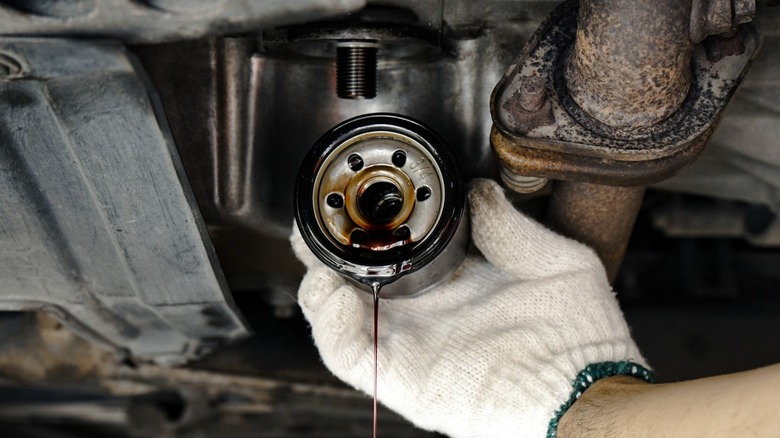 a mechanic removing an old engine oil filter
