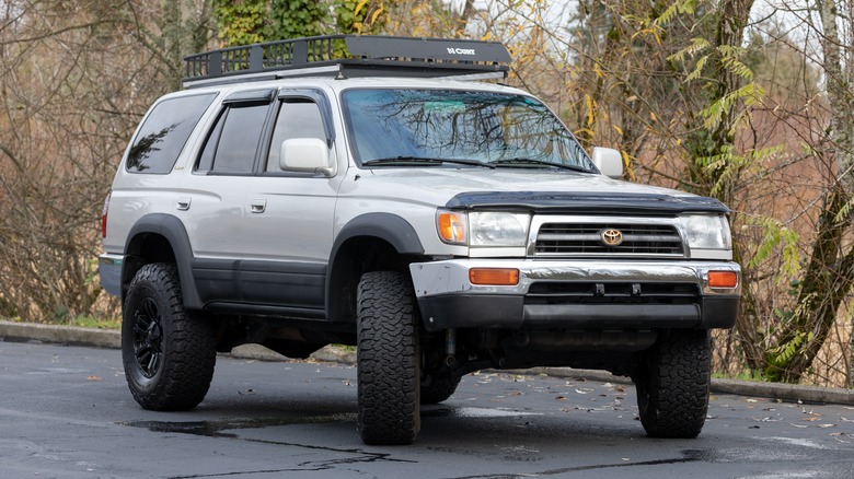A modified third generation Toyota 4Runner, front 3/4 view, silver over black
