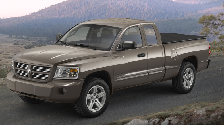 Gray 2009 Dodge Dakota Sport Extended Cab parked on a road with mountains in the background