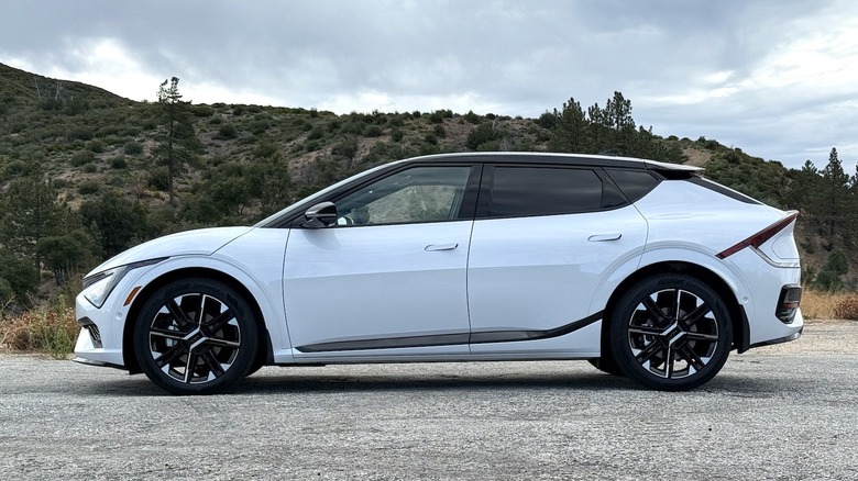 2026 Kia EV6 GT-Line side profile parked in front of trees and a hillside