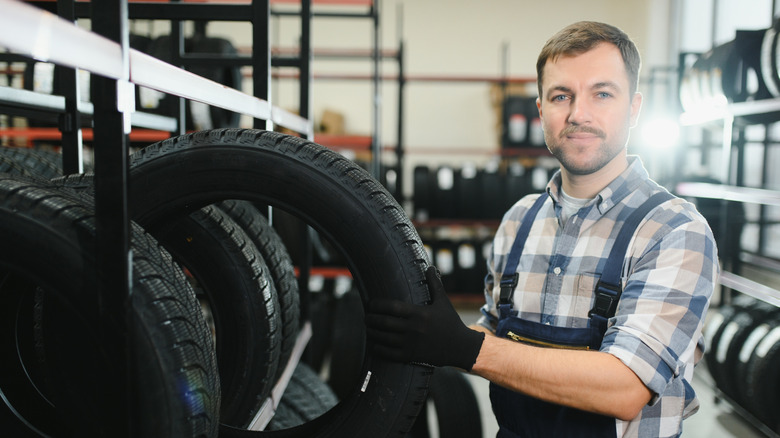 Technician in tire store holding a tire