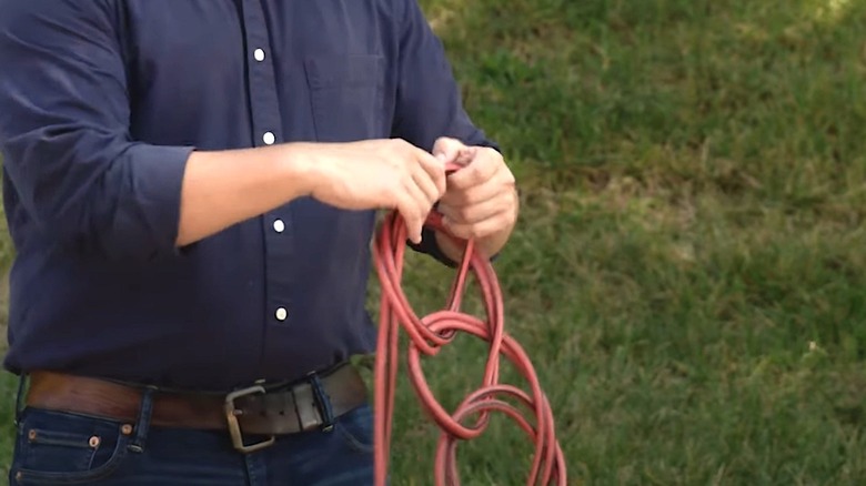 Person wrapping extension cord