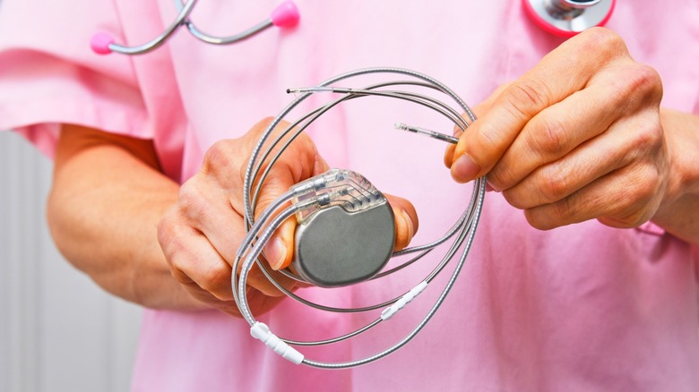 Surgeon holding a heart pacemaker