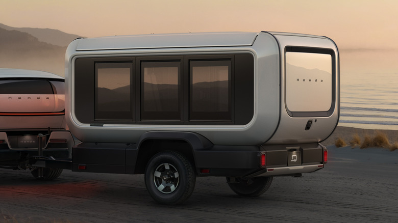 Honda Base Station prototype travel trailer in closed position being towed by upcoming Honda 0-Series SUV in seaside setting