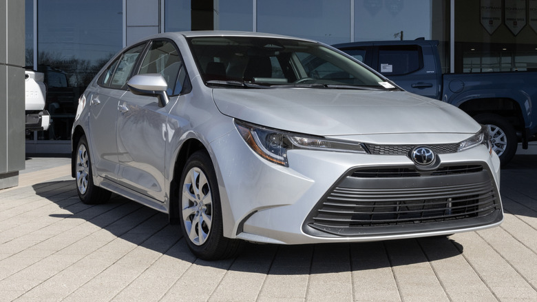 A silver 2026 Toyota Corolla LE parked in front of a dealership.