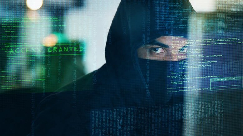 Suspicious man in balaclava with computer code overlay