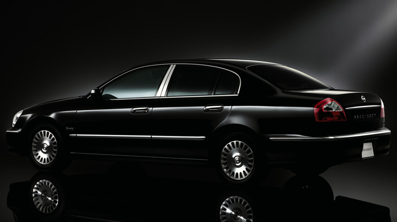2003 Nissan President in black, rear 3/4 view, dark studio shot