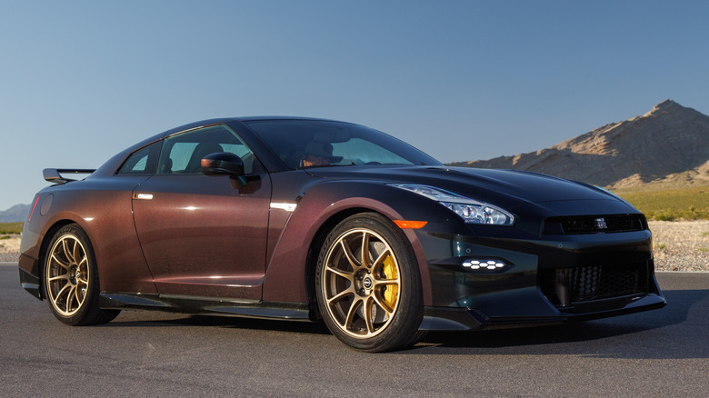 Nissan GT-R R35 in Midnight Purple parked on racetrack, front-right 3/4 view