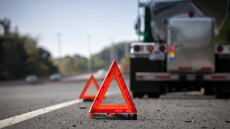 Triangular orange hazard reflectors in front of truck on highway