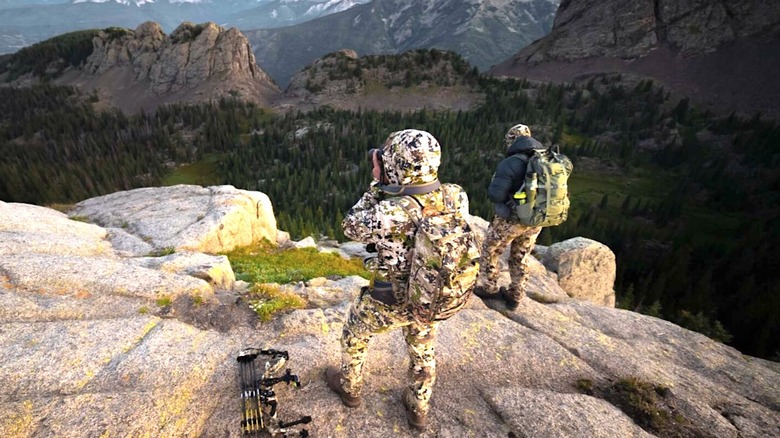 Hunters surveying a mountainous landscape