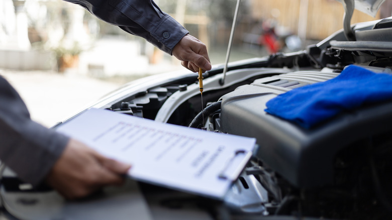 Mechanic checking the oil level using a dipstick