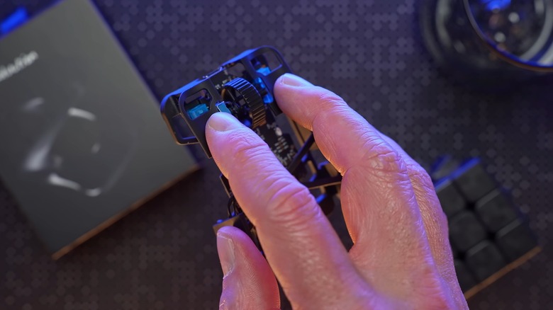 A person holding the Zeromouse Blade with fingers on the left and right click buttons