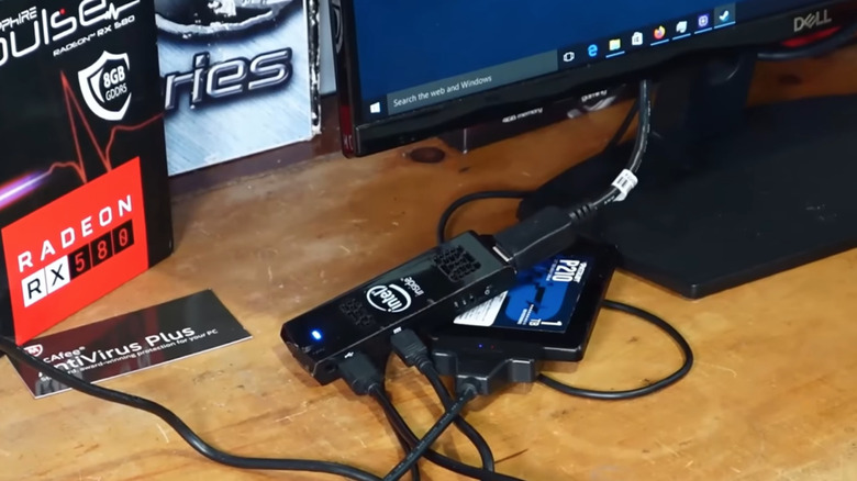 Mini PC stick plugged into computer monitor setup