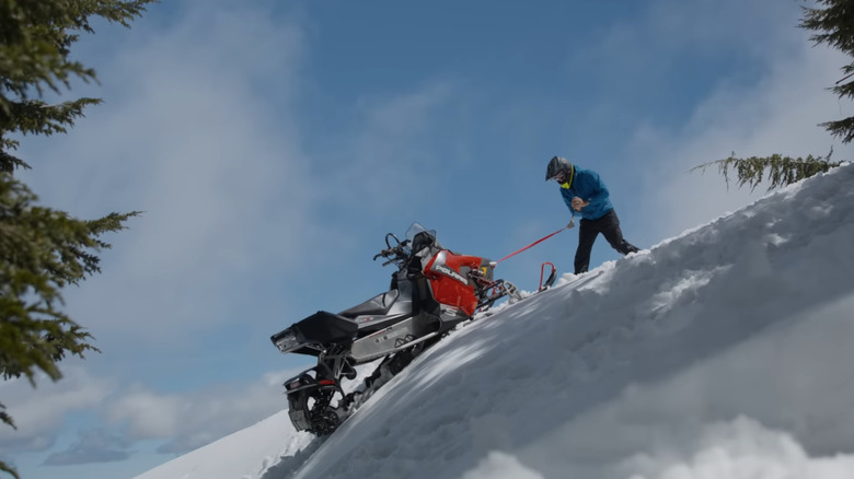 Man using Dragan Pocket Winch on snowmobile