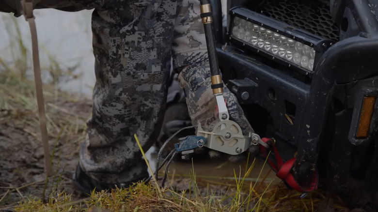 Man using Dragan Pocket Winch on ATV