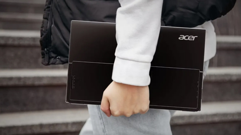 Person carrying an Acer PG1 monitor.
