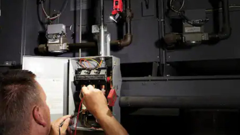 Milwaukee flashlight being used to illuminate electrical panel