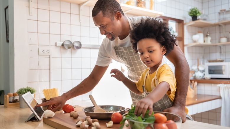 father and kid cooking in kitchen
