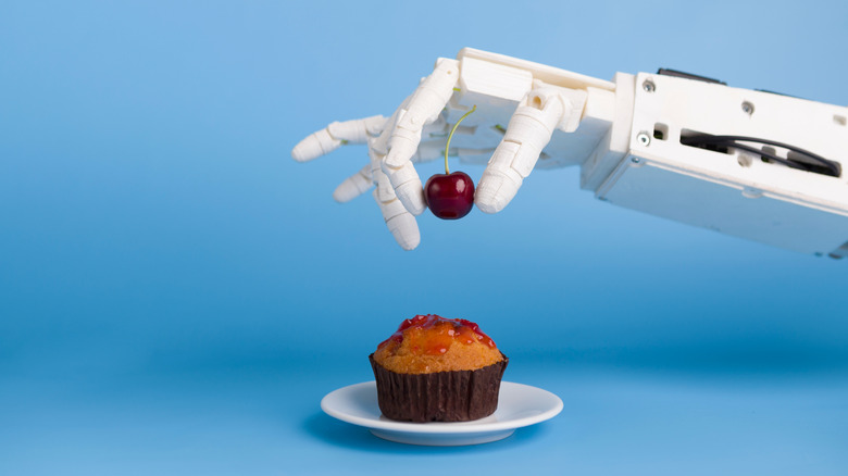 robot putting cherry on cupcake