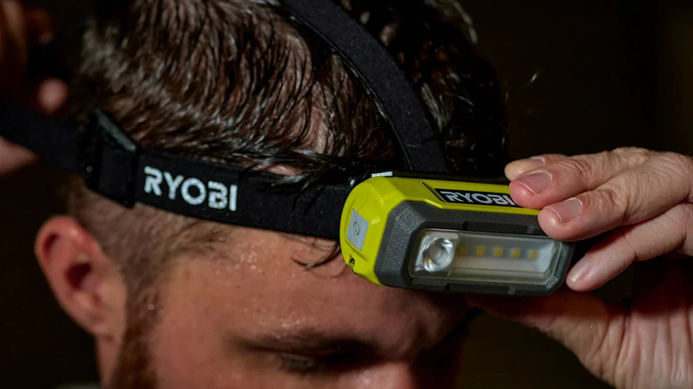 The Ryobi USB Lithium Magnetic LED Headlamp Kit on a man's head
