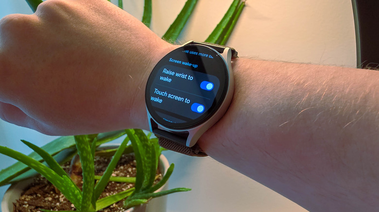 Samsung Galaxy Watch7 on a person's wrist showing screen wake-up settings