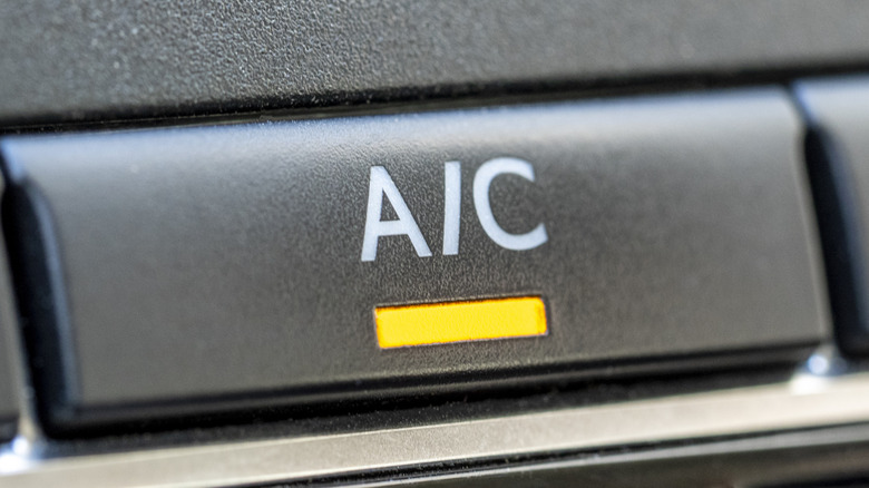 Close-up of an engaged A/C button inside a car