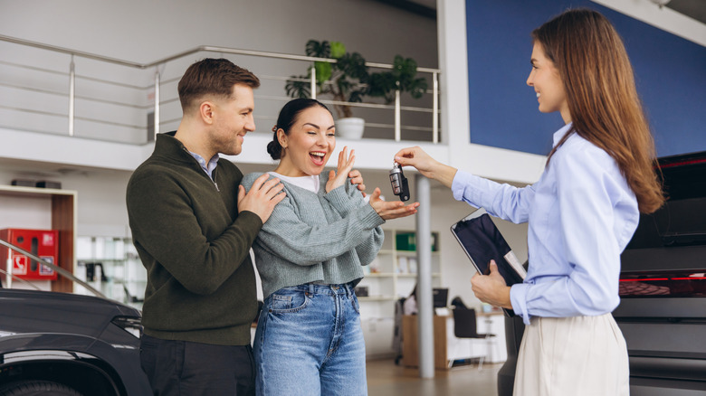 couple getting approved for a car at dealership