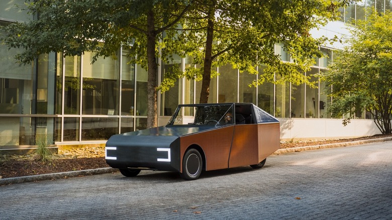 Clemson University Luminetta solar-powered car parked at the roadside under a tree