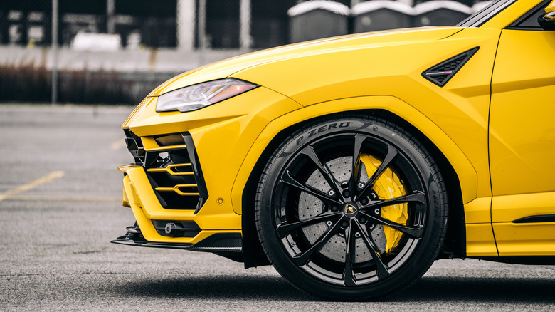 Close up of front wheel from yellow Lamborghini Urus parked