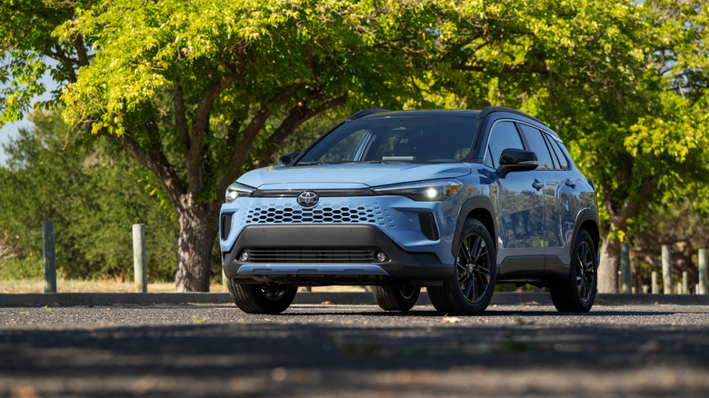 The 2026 Toyota Corolla Cross Hybrid parked on a tree-lined street