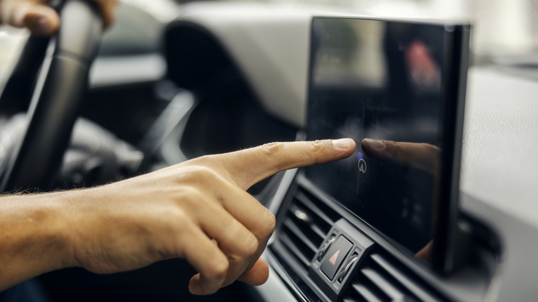 Man using an infotainment touchscreen in a car