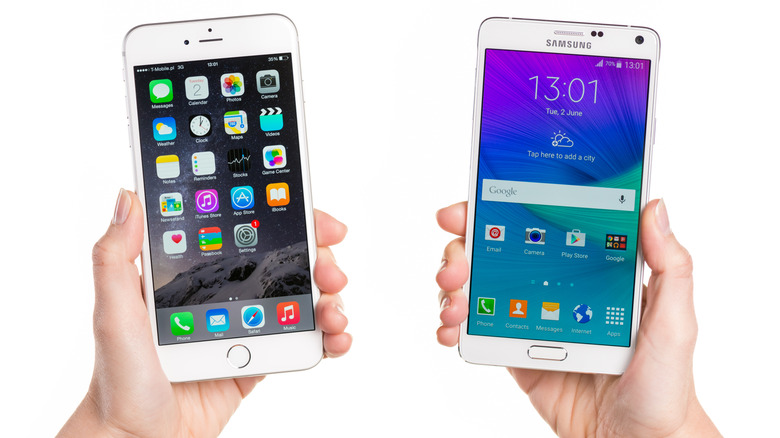 Person holding an iPhone 6 Plus and a Galaxy Note 4.