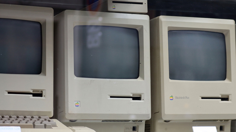 Old Macintosh computers stacked next to each other.