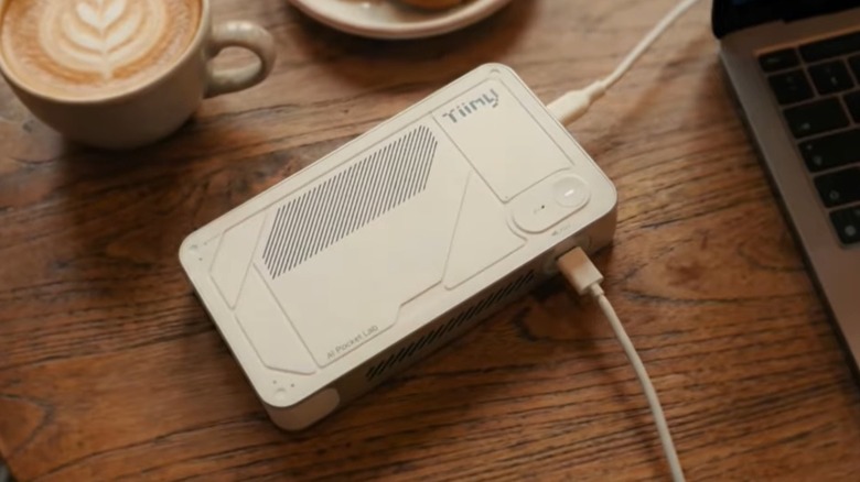 Tiiny AI supercomputer on a desktop beside a laptop