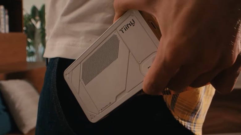 Close up of a man putting a Tiiny AI computer in his pocket