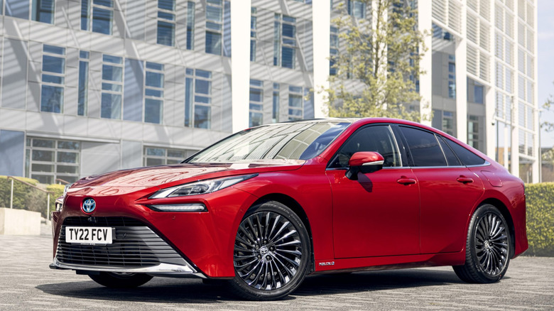 Front shot of a red 2021 Toyota Mirai in-front of a city building