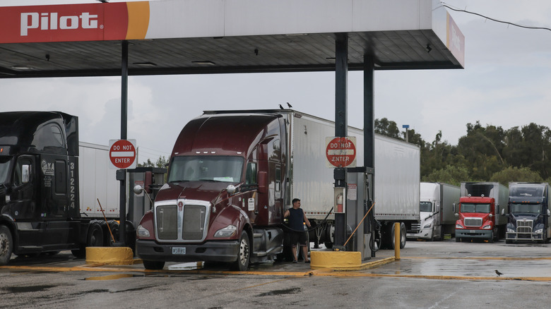 Front view of semi truck being filling up at a Pilot gas station.