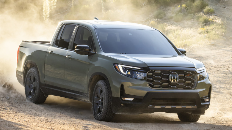 Front 3/4 view of Honda Ridgeline kicking up dust in off-road setting