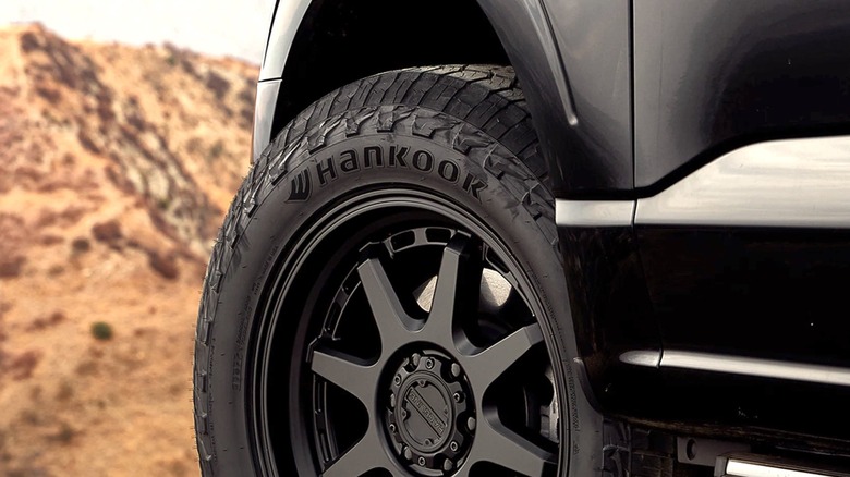 A close-up of the Hankook lettering on a set of all-terrain tires, desert in the background