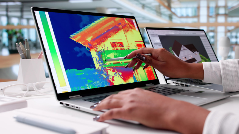 A woman looking at a thermal image on a laptop