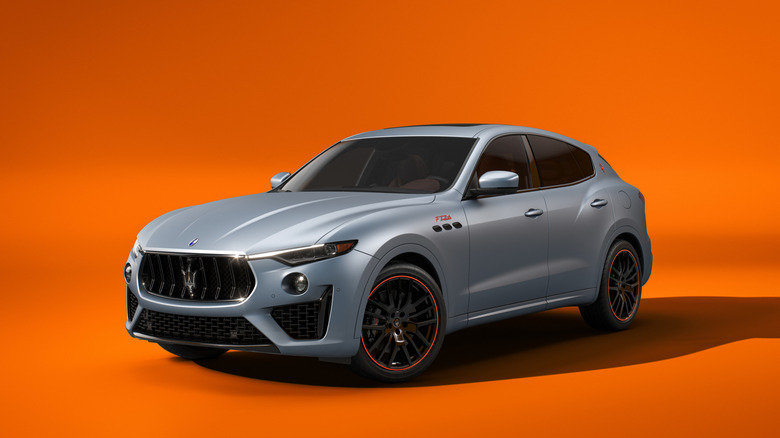 Front 3/4 view of the limited edition Maserati Levante Trofeo FTributo, gray with orange accents, orange studio background
