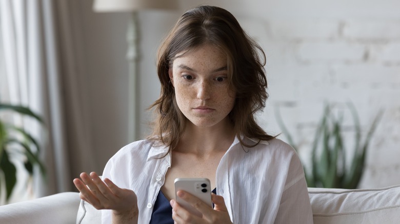 Person looking confused at smartphone