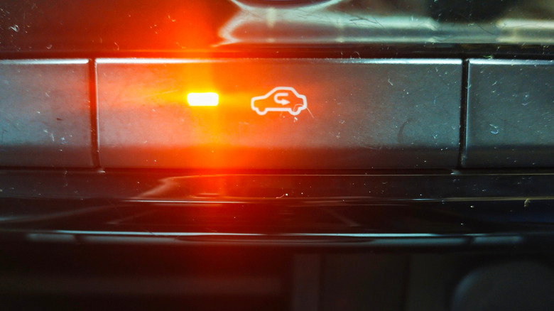 Close up of the recirculation button with the indicator light on to indicate it is activated, in the interior of a car